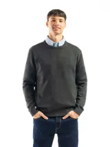 Buzo de punto liso color negro, con cuello redondo y puños y ruedo acanalados. Se lleva sobre una camisa celeste de vestir.