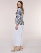 Blusa de gasa liviana con estampado animal print que combina leopardo y cebra, cuello camisero con escote en V y mangas largas con puños anchos.