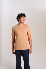 Remera de manga corta con cuello redondo, confeccionada en algodón de color beige. Presenta un pequeño logo bordado de un pingüino en el pecho.