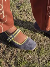 Zapato guillermina de cuero azul con ribete amarillo y hebilla plateada.