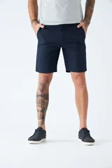 Bermuda tipo chino de gabardina, con bolsillos laterales y traseros, cierre de cremallera y botón, y pasacintos en la cintura. Presenta un diseño clásico con logo bordado.