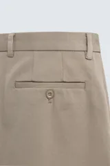 Pantalón de corte recto confeccionado en tejido de algodón con estructura twill, con bolsillos frontales y bolsillos traseros de vivo con botón.