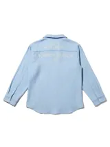 Camisa de lino rayada en tonos celeste y blanco, con cuello y botones frontales. Presenta un estampado en el frente y la espalda.