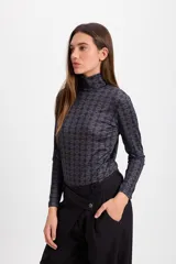 Polera de cuello alto y manga larga con estampado geométrico de rombos en tonos bordó y detalles en blanco.