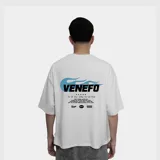 Remera de corte oversize color blanco, con estampa gráfica en la espalda que incluye el logo de la marca en negro, detalles de llamas en color celeste y texto informativo.