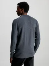 Sweater gris de lana merino con cuello alto y cremallera corta.