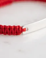 Pulsera de hilo rojo con chapa central de plata 925 lisa, diseñada con sistema de ajuste regulable.