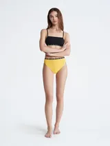 Bombacha de algodón color amarillo con cintura alta y elástico negro con logo Calvin Klein.