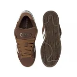 Championes Adidas modelo Campus 00s, color marrón con las icónicas tres tiras laterales en blanco. Presentan un diseño de inspiración retro con capellada de gamuza, cordones anchos y suela de goma en tono crema.