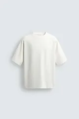 Camiseta de corte relajado confeccionada en tejido interlock de algodón con elasticidad, cuello redondo y manga corta.