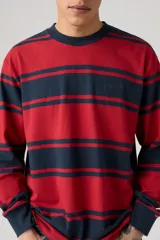 Remera de manga larga Levi's, con cuello redondo y estampado de rayas horizontales en rojo y azul marino. El logo de Levi's está bordado en el pecho.