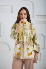 Buzo oversize color crema con estampado de hojas en tonos verde y amarillo, cuello alto con medio cierre metálico y jareta en la cintura para ajustar.