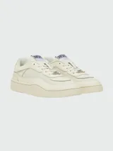 Zapatillas Diesel modelo S-Oval Skate, de diseño urbano en color crema. Presentan una silueta de perfil bajo con paneles de cuero y tejido técnico, cierre de cordones con placa metálica decorativa y etiqueta con logo en la lengüeta.