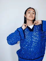 Buzo negro con cuello polo y calado, tejido a máquina con hilado serido y lurex, de estilo oversized.