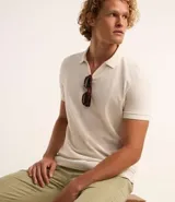 Polo de manga corta color verde salvia, con cuello polo y escote en V con borde de punto contrastante. Presenta una textura tejida sutil.