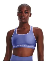Top deportivo de soporte medio Under Armour, color violeta con ribetes en tono más claro. Presenta diseño de espalda cruzada y banda elástica inferior con el logo de la marca estampado.