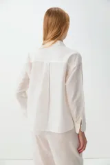Camisa de corte recto y mangas largas, confeccionada en una mezcla de lino y algodón. Presenta cuello clásico y cierre frontal con botones.