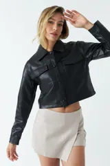 Sobrecamisa de eco cuero con corte cropped, silueta recta y bolsillos frontales con tapa. Presenta cierre frontal con botones y acabado soft.