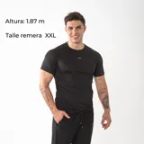 Remera de compresión negra con ajuste al cuerpo, manga corta y cuello redondo. Confeccionada en tejido técnico liviano y respirable, ideal para entrenamiento deportivo.
