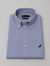 Camisa de manga larga de cotton twill en color celeste, con corte clásico, cuello con botones (button down) y un bolsillo en el pecho con detalle de ave bordada.
