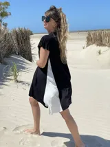 Vestido corto negro con panel lateral blanco, de corte holgado y mangas cortas con volados.