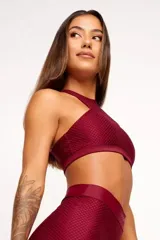 Top deportivo color bordó, con textura tipo panal 3D, cuello alto y estructura firme.