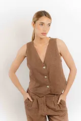 Chaleco de lino color bordó con escote en V y cierre frontal de botones. Presenta costuras a contratono y un diseño liviano ideal para el verano.