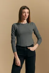 Remera blanca de manga larga con tejido acanalado, cuello redondo y corte ajustado al cuerpo. Presenta costuras verticales que definen la silueta.