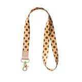 Llavero de cuello beige con estampado de lunares marrones, detalle de cuero sintético y gancho metálico.