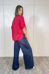 Blusa de viscosa color rojo vibrante, con diseño de corte relajado, cuello redondo y mangas cortas con dobladillo.