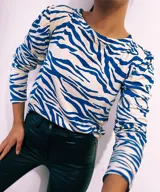 Remera de manga larga con cuello redondo y estampado de cebra en colores verde, rojo, azul y marrón.