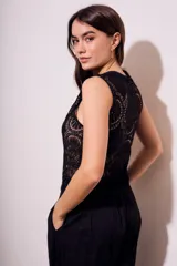 Blusa negra sin mangas de encaje con botones frontales.