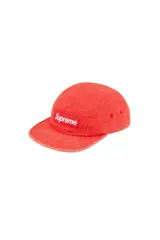 Gorra tipo camp cap de la marca Supreme, color rojo con efecto desgastado. Presenta el logo de la marca bordado en un parche rectangular frontal y ojales laterales para ventilación.