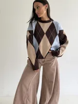 Sweater de tejido bremer con diseño de rombos en tonos marrón, beige y celeste, de cuello redondo y manga larga.