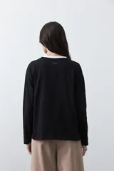 Remera de manga larga en color blanco, con calce relajado y diseño minimalista. Presenta un cuello redondo clásico y puños rectos, ideal para usar como prenda base en capas.