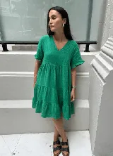 Vestido corto rojo con escote en V, mangas cortas con volados y corte escalonado.