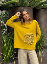 Sweater amarillo mostaza de tejido de punto con detalle de flor tejida en el frente y puños acanalados.