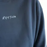 Buzo azul marino de cuello redondo, con logo bordado en el pecho y corte holgado.