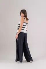 Musculosa negra con escote en V, breteles anchos y bordados geométricos blancos en cuello, sisas y frente.