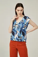 Blusa de poliéster sin mangas, con cuello en V y estampado abstracto multicolor en tonos beige, marrón, negro y naranja.