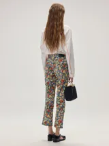 Pantalón de jean de corte recto y tiro medio con estampado floreado multicolor sobre base azul, confeccionado en algodón elastizado.