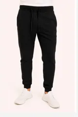 Pantalón de jogging negro con cordón ajustable en la cintura y puños elásticos en los tobillos.