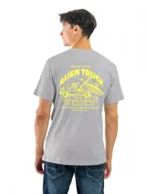 Remera de manga corta y cuello redondo, color gris oscuro o carbón, con un estampado circular blanco en el pecho que contiene texto y un logo.