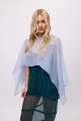 Poncho o capa corta de tela chiffon, color celeste claro, con caída fluida y escote redondo.