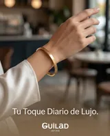 Pulsera tipo esclava rígida de acero con baño de oro, con diseño grabado en la superficie.