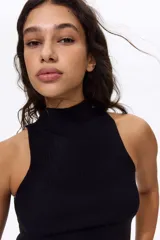Top negro en punto acanalado de mezcla suave de viscosa, con cuello tortuga y diseño sin mangas.