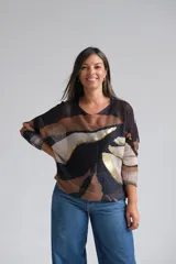 Sweter de punto con diseño abstracto en tonos negro, tostado y beige, con detalles en hilo dorado. Presenta cuello redondo, mangas tres cuartos y un corte holgado.