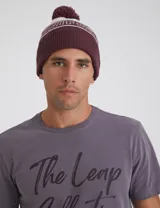 Gorro de lana tejido en jersey color bordó con pompón a tono.