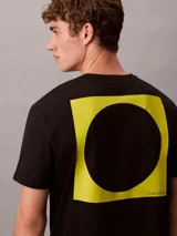 Remera de algodón negro Calvin Klein con cuello redondo, manga corta y logotipo estampado en amarillo alineado en la parte derecha del pecho.