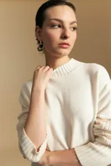 Polera de cuello alto confeccionada en tejido de punto negro, con diseño de textura acanalada en cuello, puños y ruedo, y trama vertical en mangas y espalda.